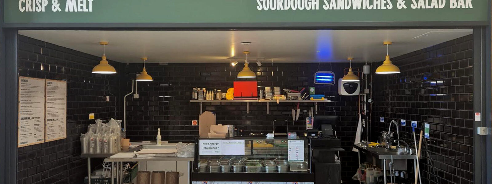 Crisp and Melt unit The Shed Bordon - shpowing the black tiled interior, with frontage above, and counters.